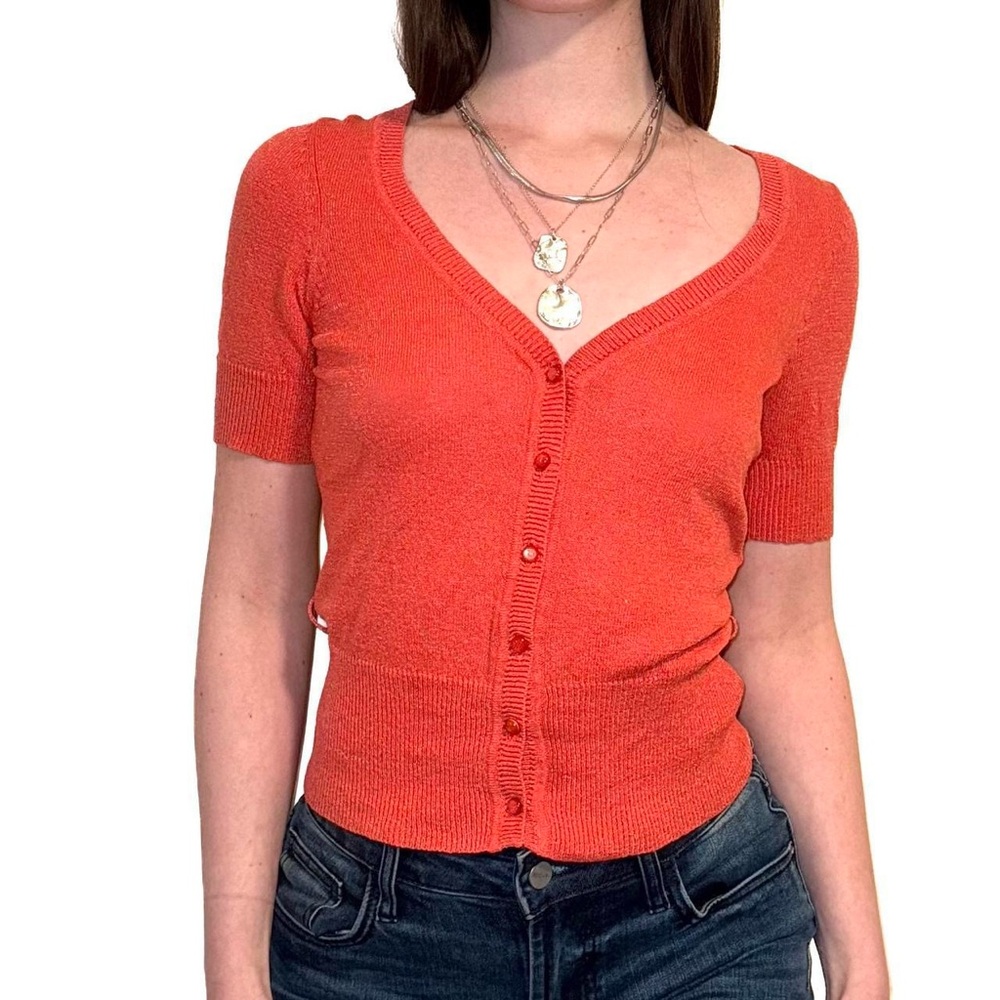 Orange short sleeve cardigan with a cute, preppy vibe.